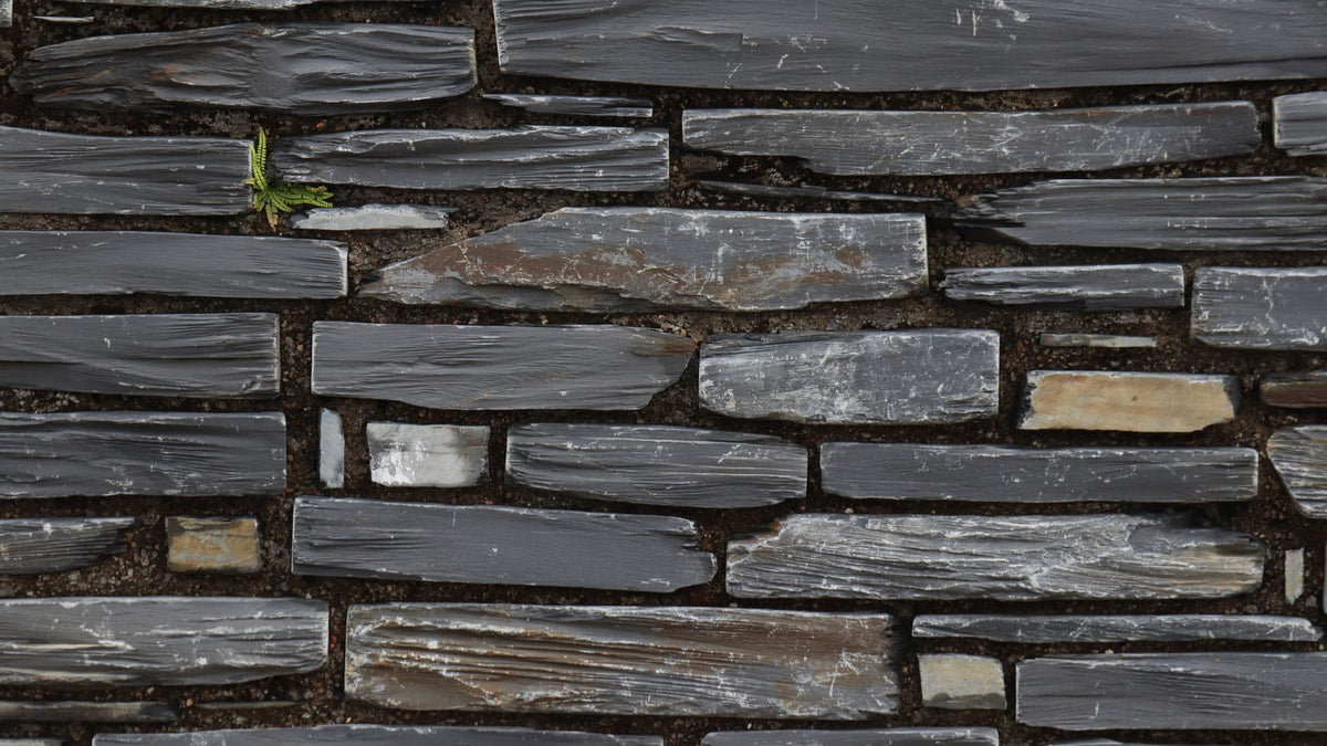 Mur en ardoise empilée aux teintes grises et brunes