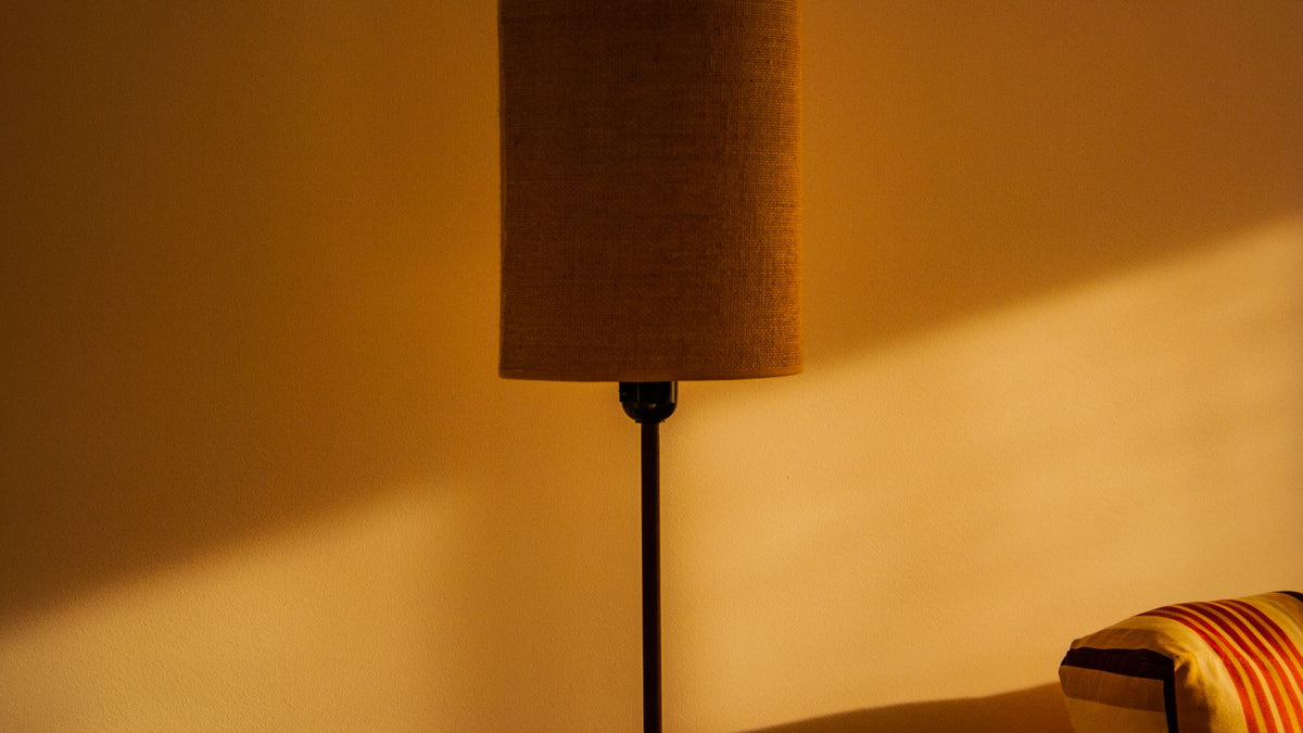 Lampe à abat-jour projetant une lumière chaude sur un mur