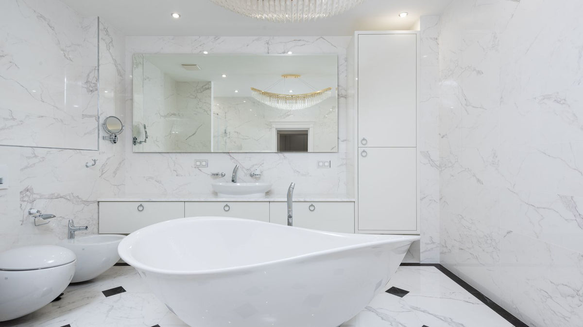Salle de bain en marbre blanc avec baignoire îlot et luminaire