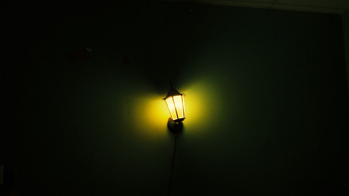 Applique murale diffusant une lumière chaude sur un mur sombre