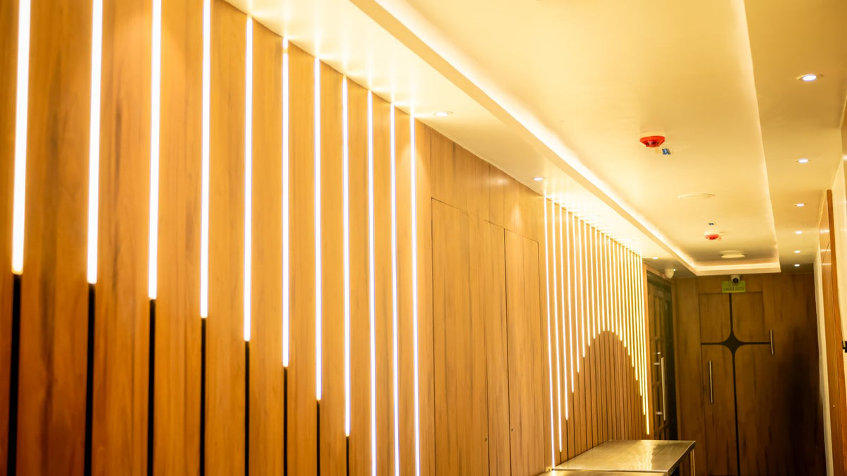 Couloir aux boiseries modernes sublimées par un éclairage indirect