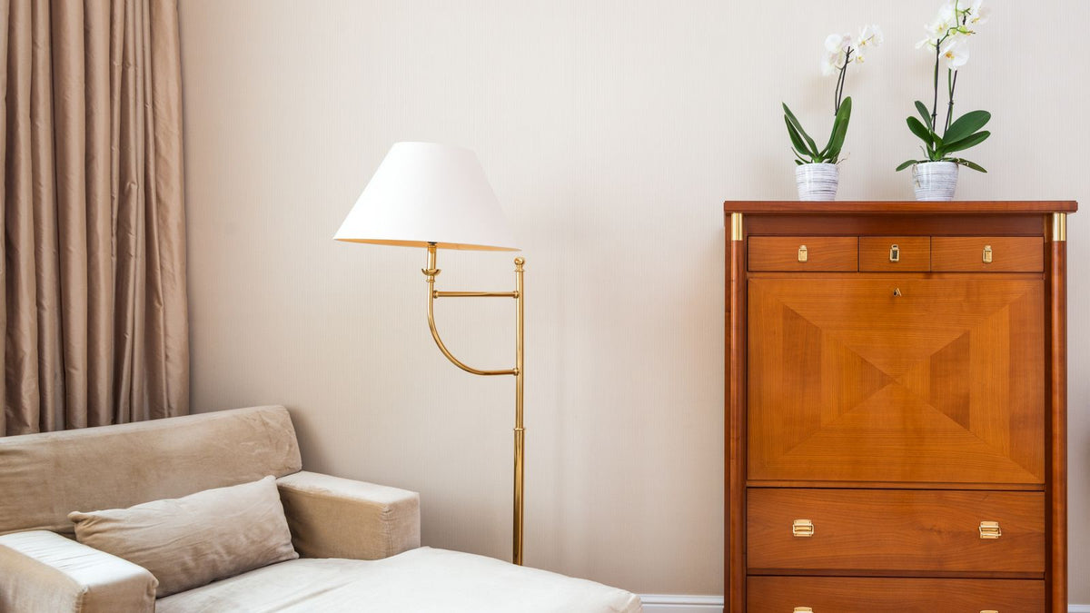 Salon de location élégant éclairé sans travaux, fauteuil beige et meuble en bois