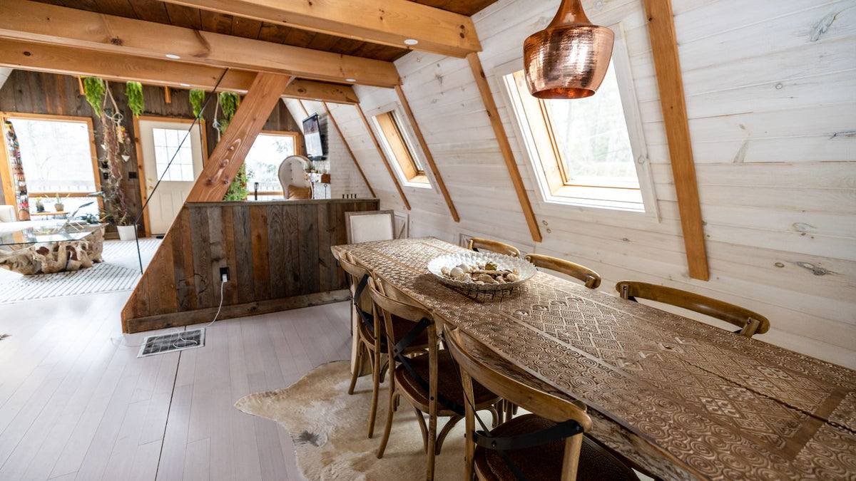 Salle à manger sous charpente en bois avec suspensions artisanales