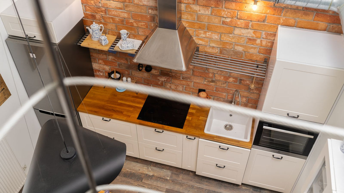 Cuisine au style industriel avec mur de briques et luminaires noirs