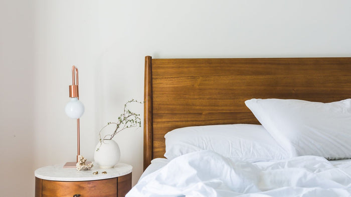 Tête de lit en bois massif et lampe de chevet allumée
