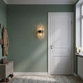 Applique cristal noire dans une entrée vert sauge à côté de la porte #noir-petit-modele