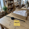 Applique sans fil noire de 50 cm montée sur son embase, posée sur une table de boutique avec son carton #noir-50-cm